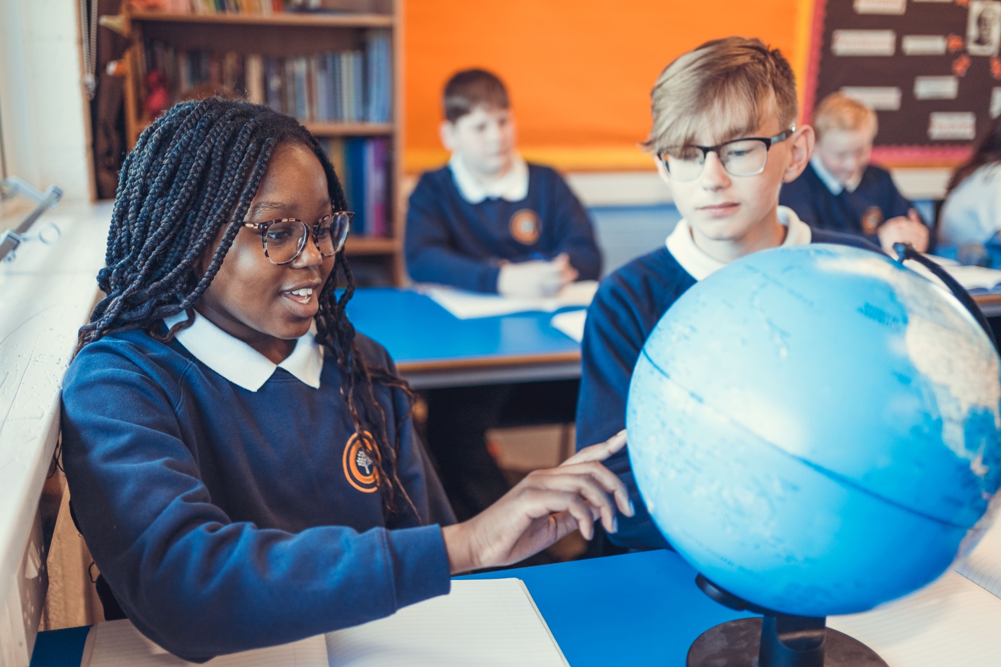 Children looking and pointing at globe